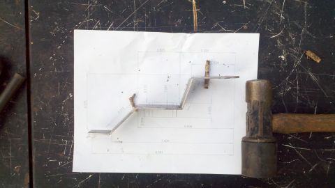 1978 Ford Bronco - A metal bracket is shown with a diagram detailing its dimensions, next to a hammer.