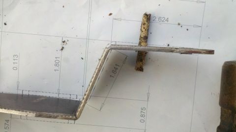 1978 Ford Bronco - metal bracket laid on a dimensioned blueprint showing fabrication measurements such as 2.624 and 1.841 inches.