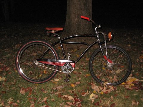 1994 Ford Bronco - A classic black cruiser bicycle with red accents sits outdoors at night, surrounded by autumn leaves.