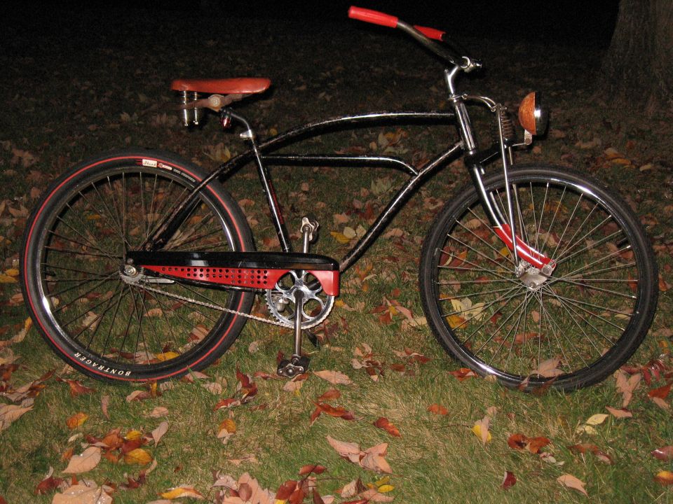 Black cruiser bicycle with red handlebars and seat, Bontrager tires
