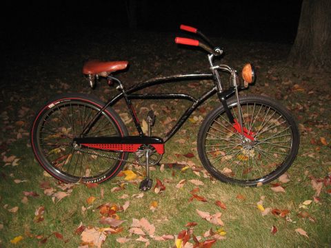 1994 Ford Bronco - A classic bicycle with a brown leather seat and red accents sits on a lawn covered in autumn leaves.