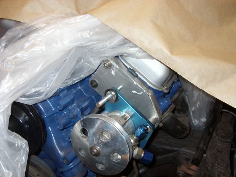 1967 Ford F-250 - Engine component, possibly a power steering pump, covered partially by plastic and paper.