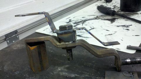 1978 Ford Bronco - A close-up view of a custom-fabricated metal bracket, likely for automotive use, showing welding and bolted components.