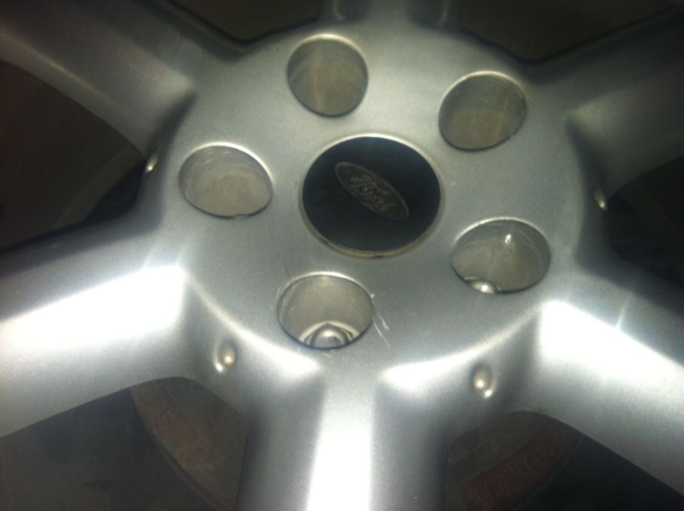 Close-up of a silver Ford wheel with a Ford logo in the center