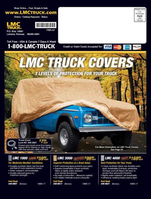 1976 Ford Bronco - A blue 1976 Ford Bronco is partially covered by a tan car cover, with trees in the background.