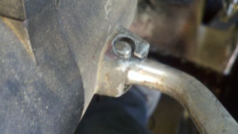 1978 Ford Bronco - Detail of a metal bracket and pipe assembly, likely from a vehicle's engine bay.