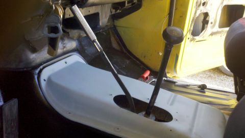 1978 Ford Bronco - Interior view of a vehicle with two floor-mounted shifters and a yellow door panel.
