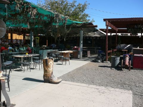 1988 Ford Bronco - A large cowboy boot sculpture stands on a patio, with tables and chairs visible in the background.