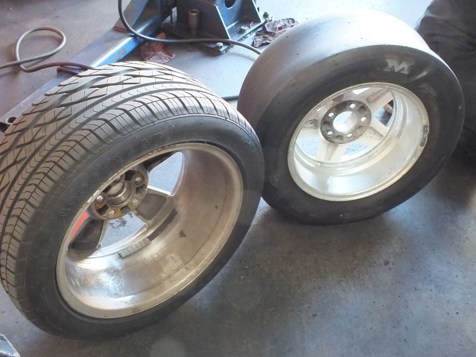 Polished aluminum wheels side by side: street tire with Goodyear tread and wide M&H drag slick