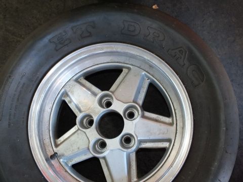 2003 Ford Crown Victoria - Face-on view of a polished five-spoke wheel with a five-lug pattern wearing an M&H ET Drag slick.