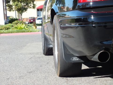 2003 Ford Crown Victoria - Low-angle shot of a Ford mud flap, rear drag tire and angled exhaust outlet.