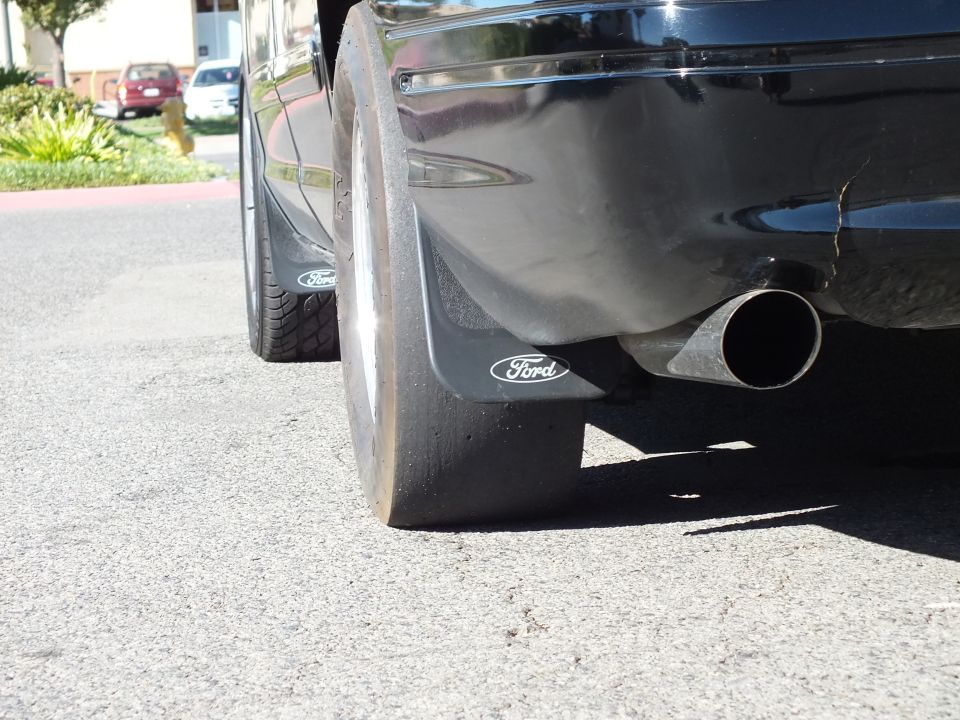 Ford branded mud flaps and chrome exhaust tip under black sedan rear bumper