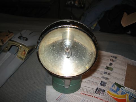 1994 Ford Bronco - A close-up view of a vintage headlight, resting on a maintenance checklist.
