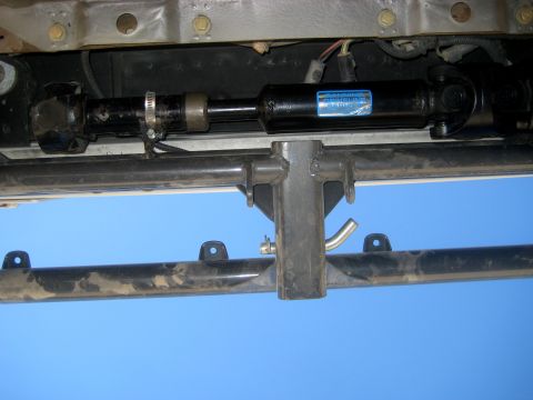 1996 Ford Bronco - Close-up view of a vehicle's driveshaft and undercarriage components against a blue sky.