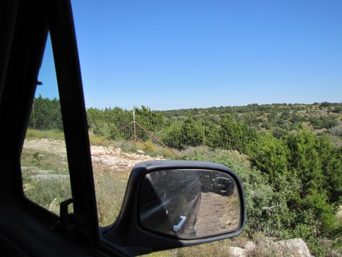1995 Ford Bronco - View from inside a vehicle looking out at a rural landscape with a fence and trees.