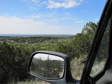 1995 Ford Bronco - A scenic overlook of a vast, tree-covered landscape under a bright blue sky with scattered clouds.