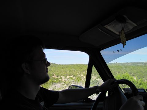 1995 Ford Bronco - View from inside a vehicle as the driver looks out at a scenic, green, and hilly landscape.