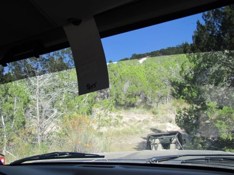 1995 Ford Bronco - Driving on an off-road trail with another vehicle visible ahead. A tag is hanging from the windshield.