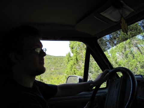 1995 Ford Bronco - Driver's perspective from inside a vehicle, looking out at a wooded landscape.