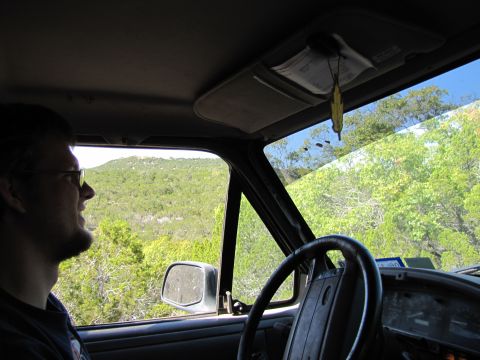 1995 Ford Bronco - View from inside a vehicle as it travels through a scenic, tree-covered terrain.