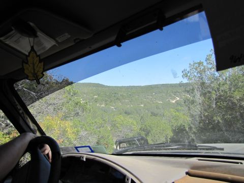 1995 Ford Bronco - Driving through a scenic landscape with another vehicle ahead on the dirt road.