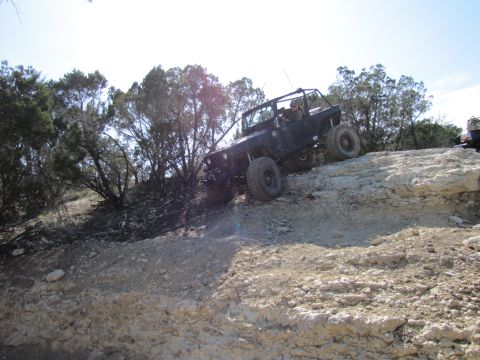 1995 Ford Bronco - Off-road vehicle navigating challenging rocky terrain on a sunny day.