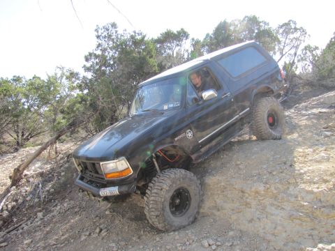 1995 Ford Bronco - This 1995 Ford Bronco is navigating a challenging off-road trail with steep, rocky terrain.