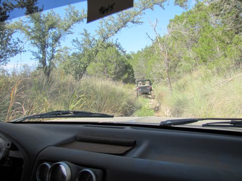 1995 Ford Bronco - View from inside a vehicle on a sunny day, looking out at a natural landscape.