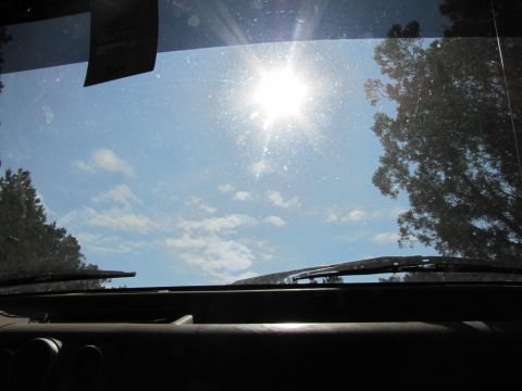 1995 Ford Bronco - View from inside a vehicle looking out at the sun on a clear day.