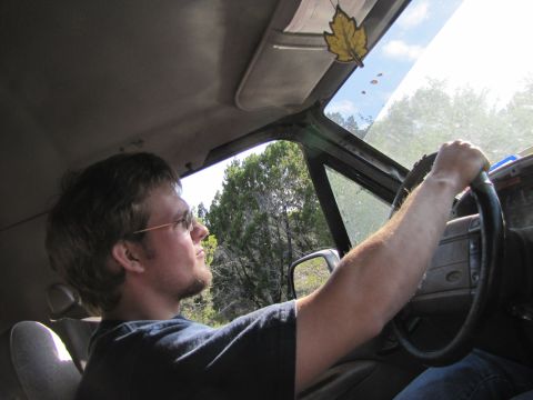 1995 Ford Bronco - Driver's perspective from inside the vehicle, with trees visible through the windows.