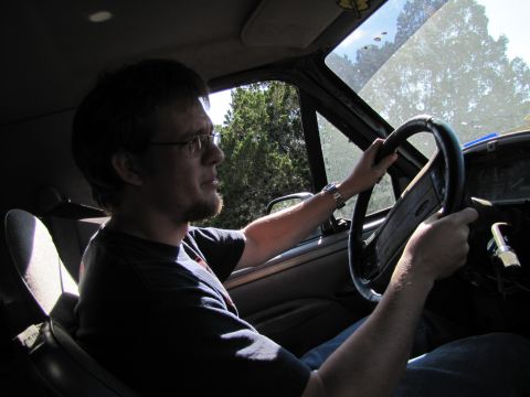 1995 Ford Bronco - Interior view of a man driving a 1992 Ford Bronco, with trees visible through the windshield.