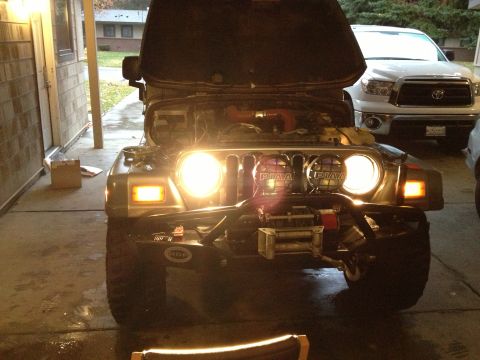 2005 Jeep Wrangler - A 2005 Jeep Wrangler is parked with its hood open, illuminated by its headlights and auxiliary PIAA lights.