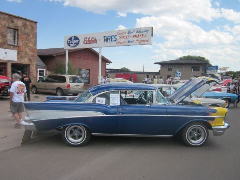 1991 Ford LTD Crown Victoria - A classic blue and silver Chevrolet Bel Air is displayed at an outdoor car show with its hood open.