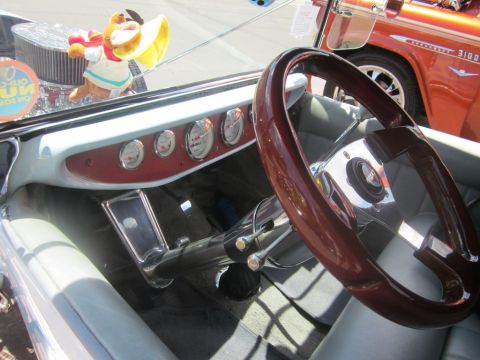 1991 Ford LTD Crown Victoria - Interior view of a classic car with multiple gauges and a wooden steering wheel, with another vehicle in the background.