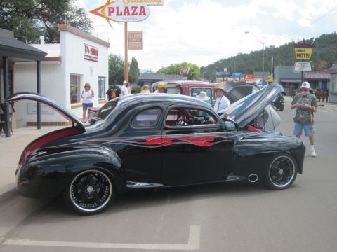 1991 Ford LTD Crown Victoria - A customized coupe with flame decals is displayed at an outdoor event with its hood and trunk open.