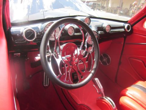 1991 Ford LTD Crown Victoria - The interior of a car features bright red upholstery and a custom steering wheel with chrome accents.
