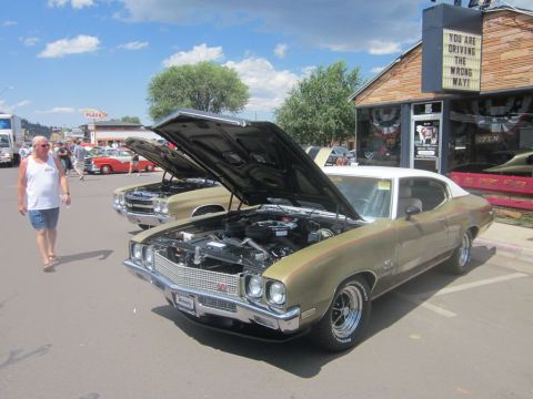 1991 Ford LTD Crown Victoria - Gold Buick GSX at a car show, hood open, with another classic car in the background.
