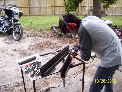 1990 Ford Bronco - Person welding metal outdoors with a motorcycle nearby.