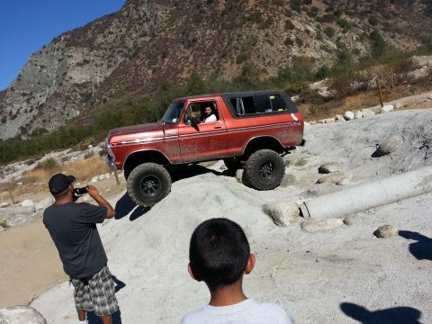 1978 Ford Bronco - This 1978 Ford Bronco navigates a rocky, off-road terrain under a clear blue sky.