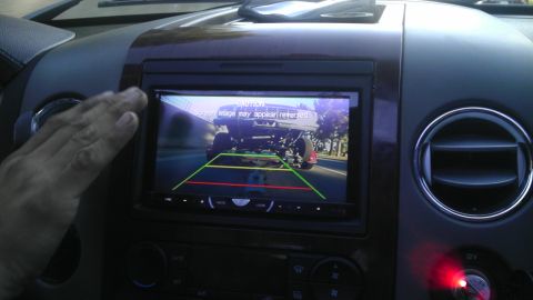 1978 Ford Bronco - The backup camera displays a view of a lifted truck, with a caution message on screen.