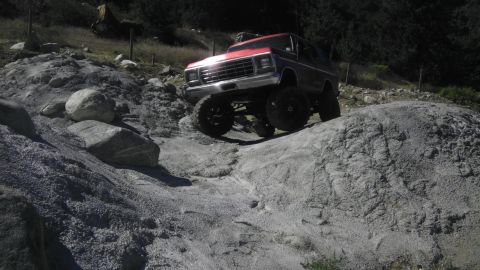 1978 Ford Bronco - A 1978 Ford Bronco navigates a rocky terrain with its suspension articulated.