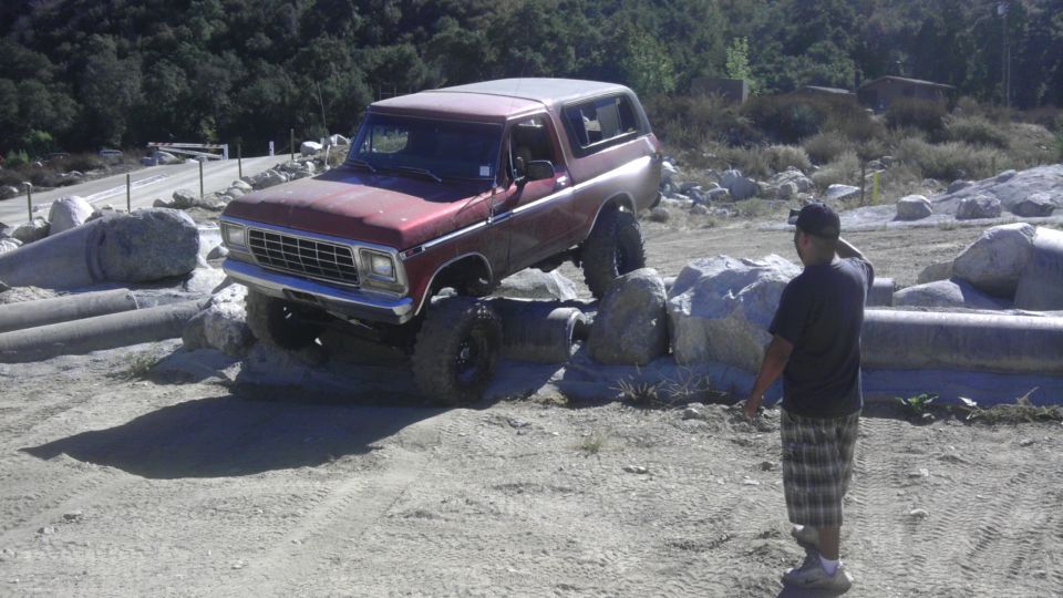 Red 1978 Ford Bronco navigating rocks off-road
