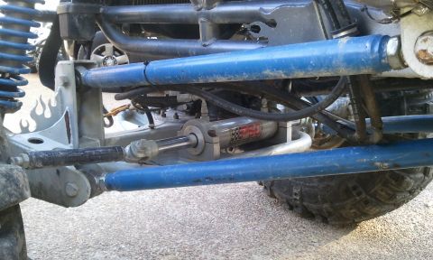 1967 Ford Mustang - Close-up view of an off-road buggy's suspension system, blue shocks and a PBC hydraulic steering component.