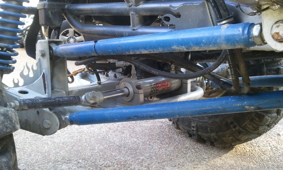 Off-road buggy suspension with blue shocks, hydraulic steering, and a PBC shock absorber