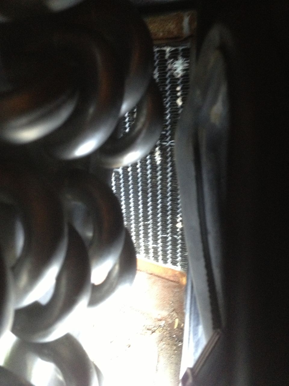 Close-up of exhaust manifold pipes next to a radiator