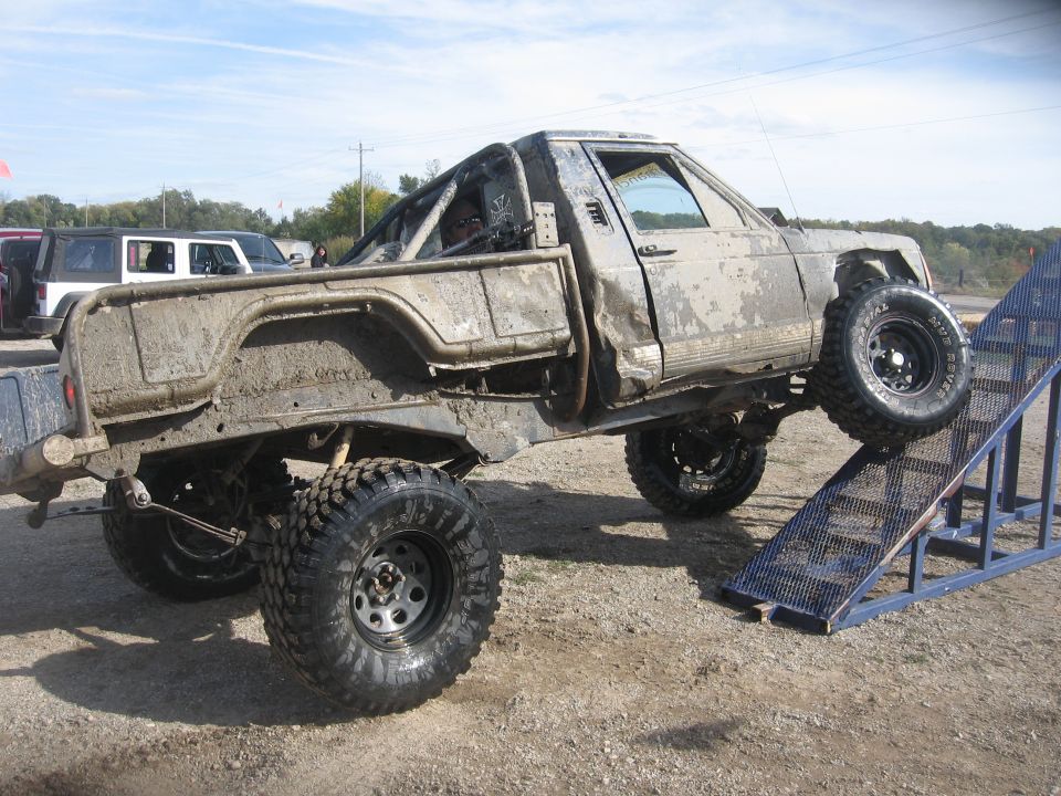 1987 Jeep Comanche 3q-front view, mud-covered, on a ramp
