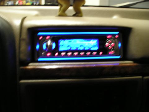 1996 Ford Bronco - Aftermarket car stereo with blue lighting and red buttons installed in a vehicle's dashboard.