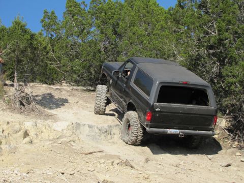 1995 Ford Bronco - This 1995 Ford Bronco is navigating a challenging off-road trail with steep rock formations.