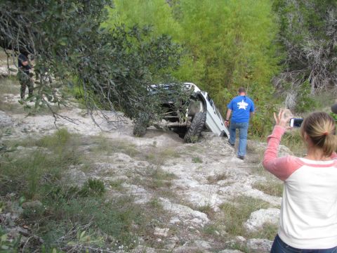 1995 Ford Bronco - A white SUV is stuck on a rocky incline, with onlookers documenting the scene.