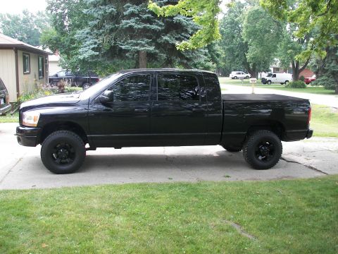 1988 Ford Bronco - A black pickup truck is parked on a driveway, with other vehicles visible in the background.
